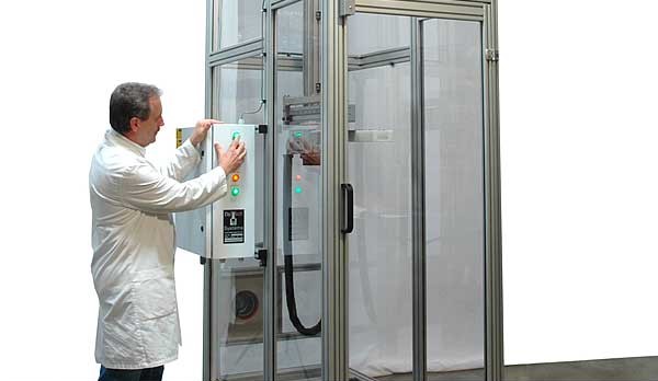 A man in a lab coat is opening a machine