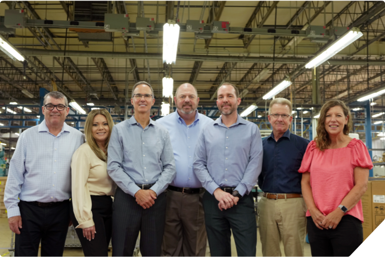 A group of people standing next to each other in a warehouse
