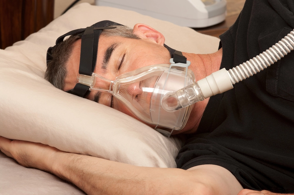 Person sleeping with a CPAP machine